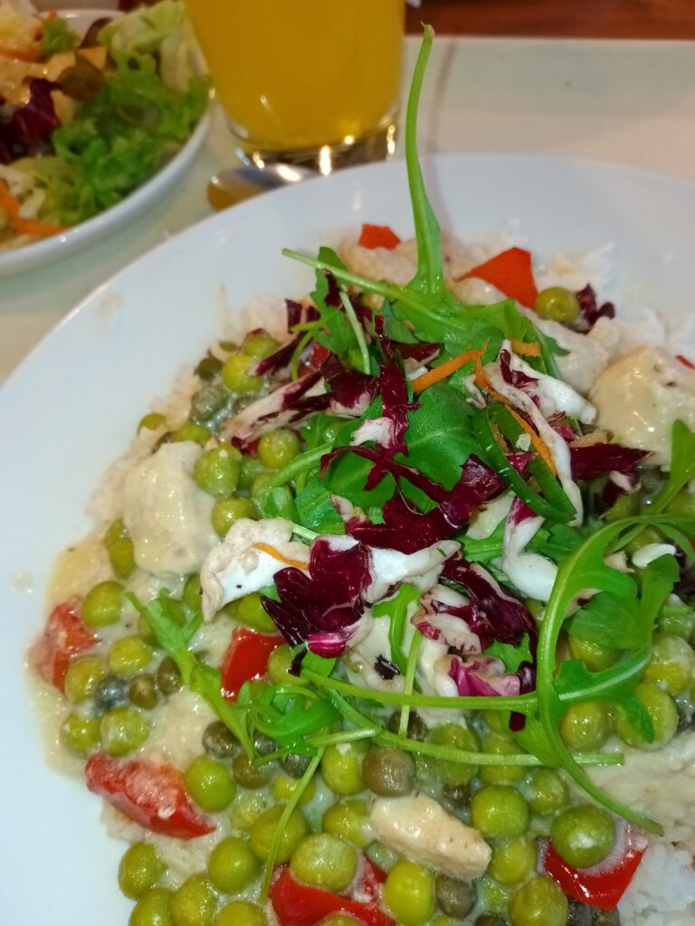 Foto: putenfrikassee mit kapern, erbsen und roter paprika auf basmatireis + kleinem salat